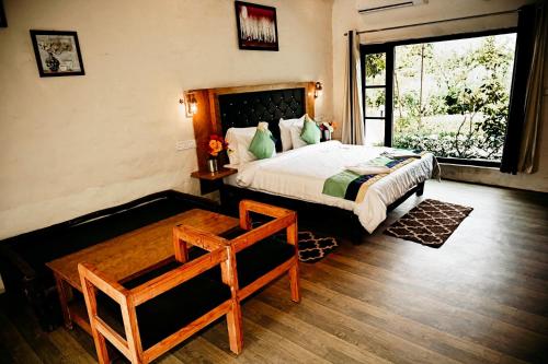 um quarto com uma cama grande e uma janela em Corbett Tiger Retreat em Rāmnagar