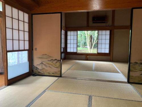 an empty room with glass doors and windows at Glamp House HANANOMORI - Vacation STAY 12585 in Yotsukaidō