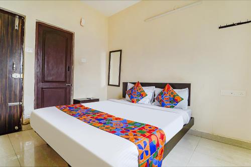 a bedroom with a large bed with a colorful blanket on it at FabExpress Vangal Nest in Pīlamedu