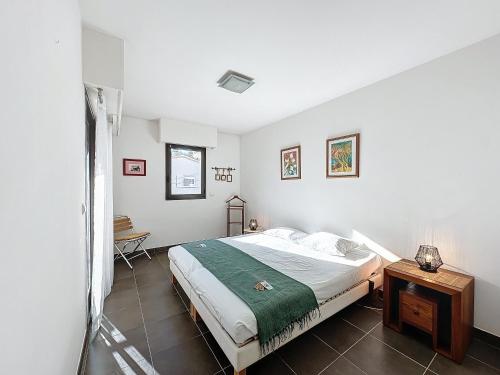 une chambre blanche avec un lit et une table dans l'établissement PON2 - 2 pièces avec piscine et terrasse, à Cannes