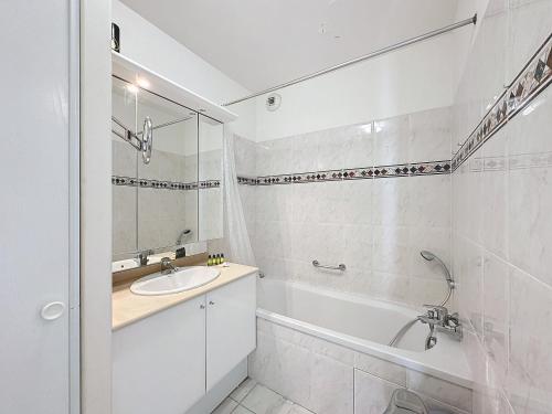 une salle de bain blanche avec un lavabo et une baignoire dans l'établissement PON2 - 2 pièces avec piscine et terrasse, à Cannes