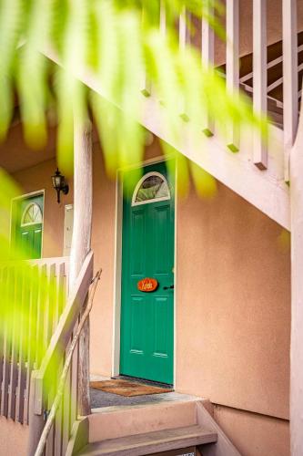 a green door on the side of a building with stairs at Volcano Inn Bed n Breakfast in Volcano