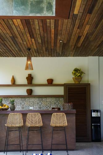 a kitchen with two stools and a counter with a bar at Pandan Villas, El Nido in El Nido