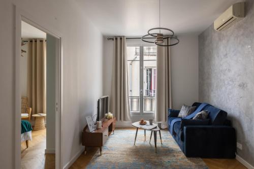 un salon avec un canapé bleu et une télévision dans l'établissement Serenity chic apartment Nice center, à Nice