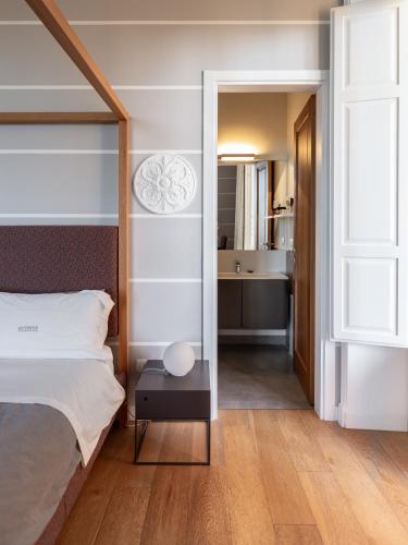a bedroom with a bed and a view of a bathroom at Euterpe LHT in Agrigento