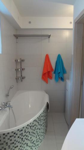 uma casa de banho com uma banheira, um lavatório e toalhas em JANA apartments em Bratislava