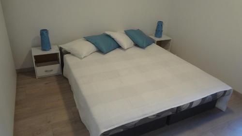 um quarto com uma cama grande e almofadas azuis em JANA apartments em Bratislava