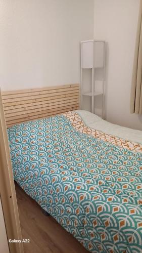 Ce lit se trouve dans une chambre dotée d'un couvre-lit. dans l'établissement Appartement proche mer avec jardin, à Saint-Cyprien