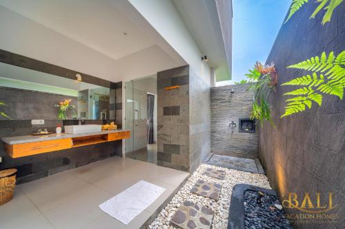 y baño con ducha, lavabo y espejo. en Premium 4BR Villa + Private Pool +Ocean view! en Tegallengah