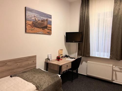 a hotel room with a desk and a bed and a deskictericter at Hotel Dietrichsdorfer Hof in Kiel