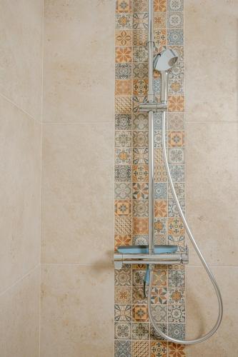 une douche dans une salle de bain avec un mur carrelé dans l'établissement Serenity chic apartment Nice center, à Nice