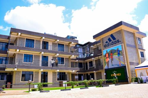 un immeuble d'appartements avec un panneau indiquant adidas dans l'établissement Kechei Centre, à Iten