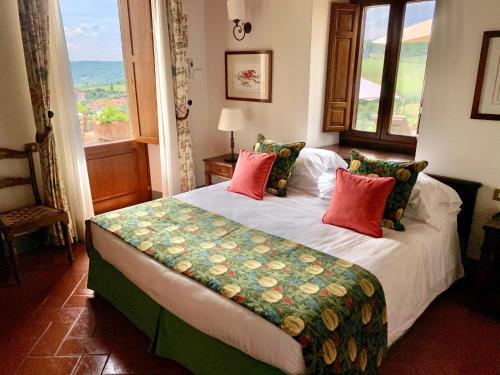 a bedroom with a large bed with a large window at Capannelle Wine Resort in Gaiole in Chianti
