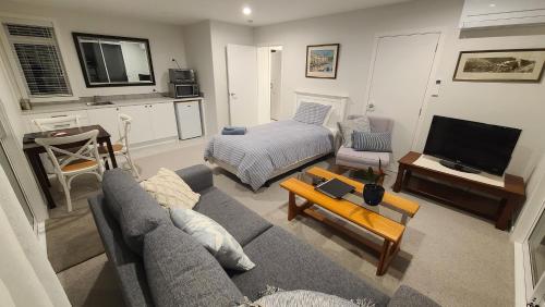 タウランガにあるStylish Matua Apartmentのソファとベッドのあるリビングルーム