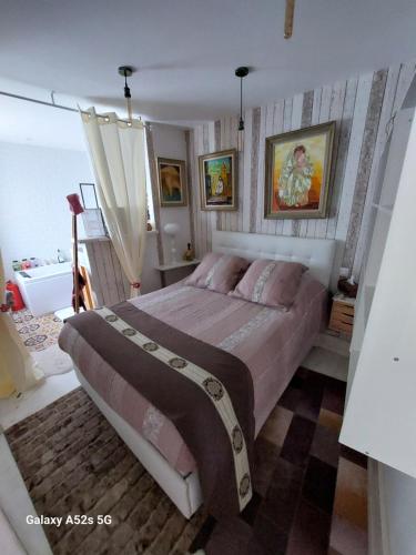 um quarto com uma cama grande e almofadas cor-de-rosa em Demeure Prosper 1 chambre d'hôte avec petit déjeuner compris em Labégude