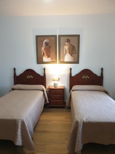 een kamer met 2 bedden en een tafel met een lamp bij Casa de Pueblo en Ossa de Montiel in Ossa de Montiel