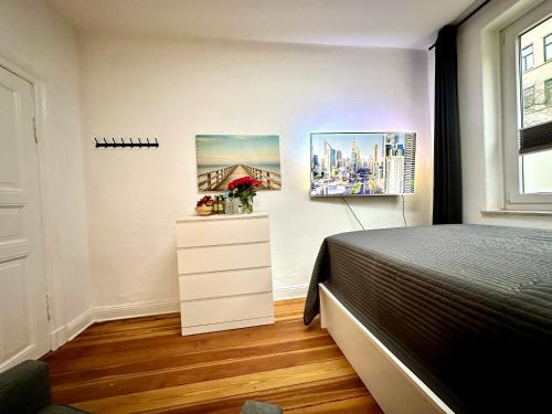 a bedroom with a bed and two paintings on the wall at Schicke Altbauwohnung in Kiel Mitte 24-7 Check In in Kiel