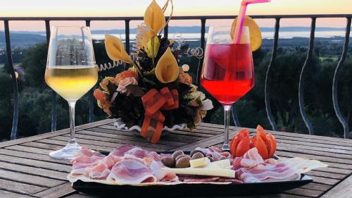 two glasses of wine and a plate of food on a table at La Perla Hotel in SantʼAnna Arresi