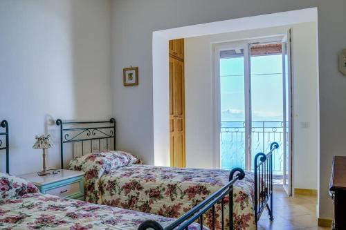 een slaapkamer met 2 bedden en een balkon bij A Casa Romano in Ravello