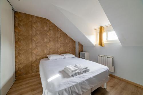 a bedroom with a bed with three towels on it at Home - Yver - Séjour à Auxerre in Auxerre
