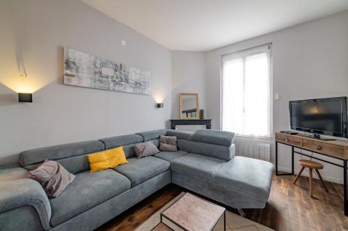 ein Wohnzimmer mit einem Sofa und einem TV in der Unterkunft Home - Yver - Séjour à Auxerre in Auxerre