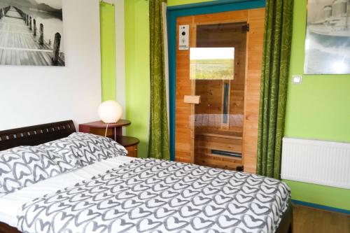 a bedroom with a bed and a glass door at Bijzonder chalet An der Marina met sauna in Anjum