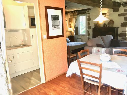 uma cozinha e uma sala de estar com uma mesa e uma cozinha em Le gîte d'Etienne em Joué-du-Bois