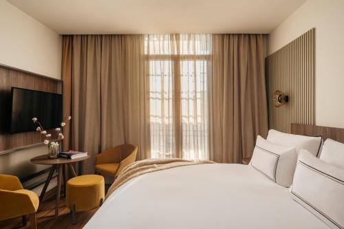 una habitación de hotel con una cama grande y una mesa en Casa de las Artes, member of Meliá Collection, en Madrid