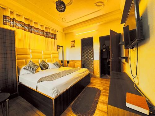 Maa Tara Anchal Cottage By BYOB Hotels في شيملا: غرفة نوم فيها سرير وتلفزيون