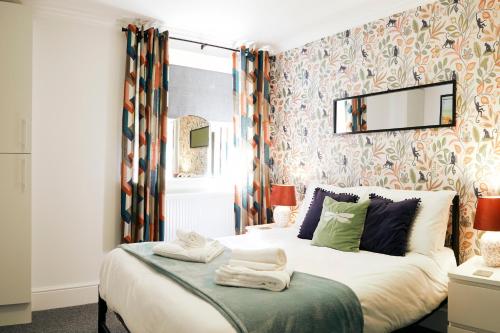 1 dormitorio con 1 cama grande y papel pintado con motivos florales en Rockpool's with outside area. en Scarborough