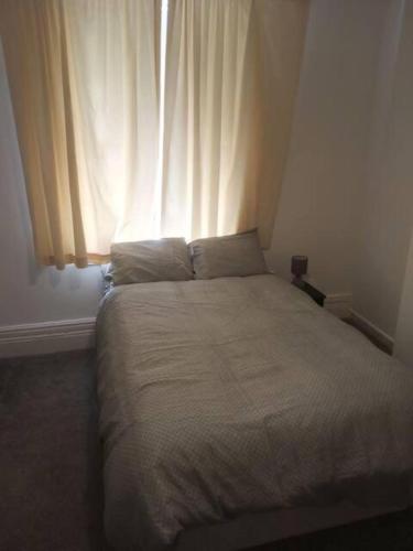 a bed in a bedroom with a window at Double-bed (E1) close to Burnley city centre in Burnley