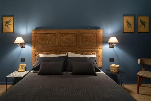 a bedroom with a large bed with blue walls at Casa Bellezia- design e storia nel cuore di Torino in Turin