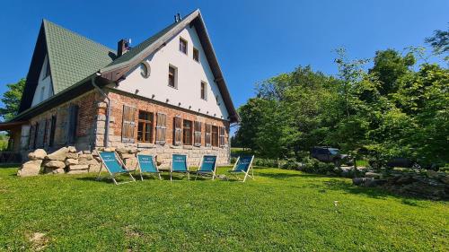 a group of chairs sitting in front of a building at Chata w Stołowych in Łęzyce