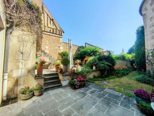 a courtyard with potted plants and stairs in a building at Home - Visitandines - Séjour à Auxerre in Auxerre