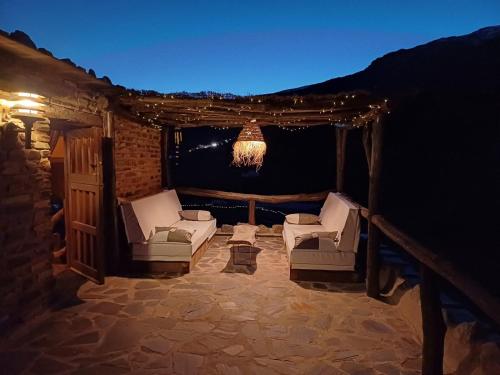 a patio with two chairs and a chandelier at Casa Rural Cortijo Molino Altero in Trevélez