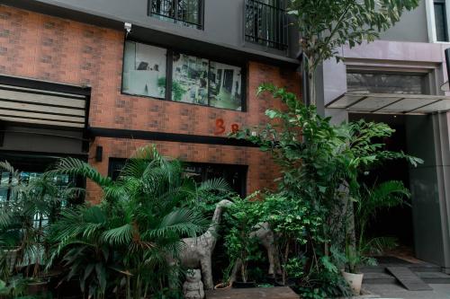 a building with a bunch of plants in front of it at BBHouse Khlongtan in Bangkok