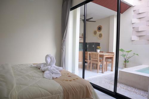 ein weißes Häschen auf einem Bett im Schlafzimmer in der Unterkunft Puspa Villa in Kerobokan