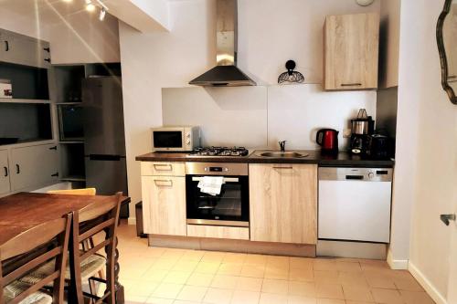 cocina con fregadero y fogones horno superior en Home - Vildieu - Séjour à Coulanges, en Coulanges-la-Vineuse