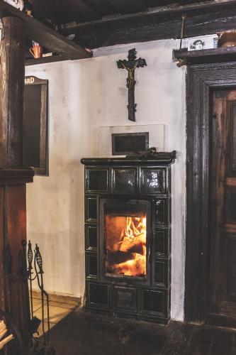 a fireplace in a room with a cross on the wall at Chalupa Hejmovka in Špindlerův Mlýn