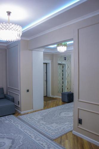 a living room with a door and a chandelier at Стильная и уютная двухкомнатная квартира. in Bishkek