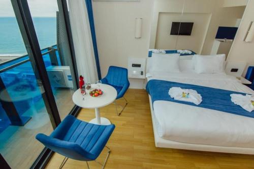 1 dormitorio con 1 cama, mesa y sillas en Orbi Apartment, en Batumi