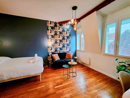 une chambre avec un lit et une chaise dans l'établissement Toit & Bois - Séjour à Auxerre, à Auxerre