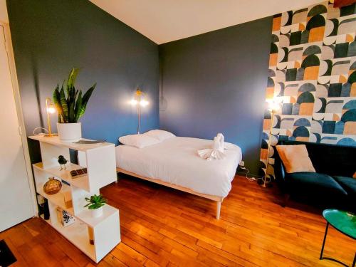 une chambre avec un lit blanc et un canapé dans l'établissement Toit & Bois - Séjour à Auxerre, à Auxerre