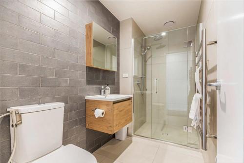 a bathroom with a shower and a toilet and a sink at Cozy apartment by Eden Park in Auckland