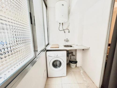 een wasmachine in een kleine badkamer met een wastafel bij Madrid Rio Antonio López B in Madrid
