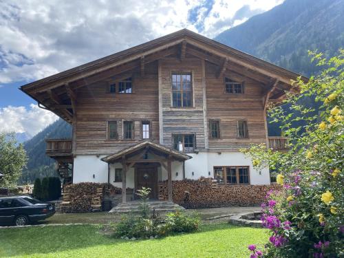 a large wooden house with mountains in the background at Hideaway Eggerfeld in Flattach