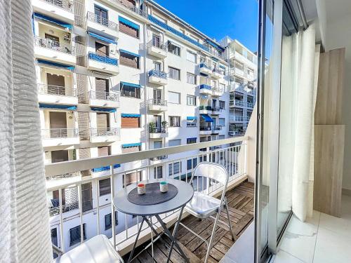- un balcon avec une table et des chaises en face d'un bâtiment dans l'établissement Nestor&Jeeves - PALMA BEACH - Proche Mer, à Nice