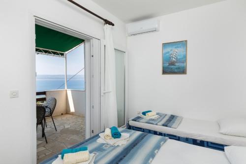 - une chambre avec 2 lits et une vue sur l'océan dans l'établissement Apartments with a parking space Pisak, Omis - 5975, à Pisak