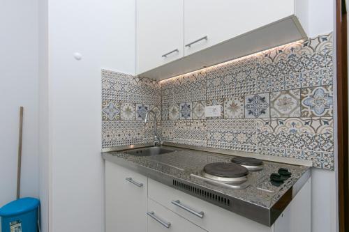 eine Küche mit einer Spüle und einer Fliesenwand in der Unterkunft Apartments with a parking space Pisak, Omis - 5975 in Pisak
