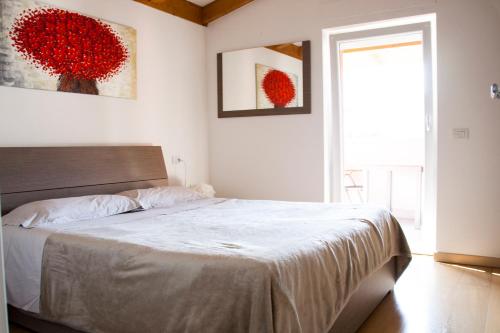een slaapkamer met een bed met witte lakens en een raam bij Porta del Garda (CIPAT: 022079-AT-670565) in Dro